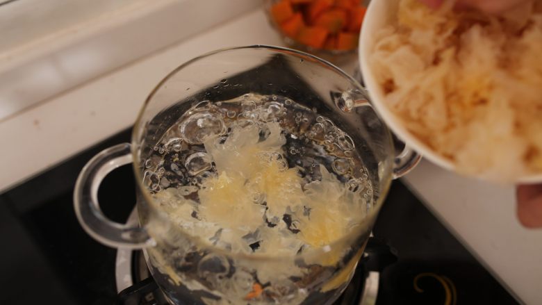 润肤润肺银耳南瓜羹,锅中加入1000ml水,大火烧沸,.放入银耳煮5分钟,盖上锅盖,转小火炖40分钟