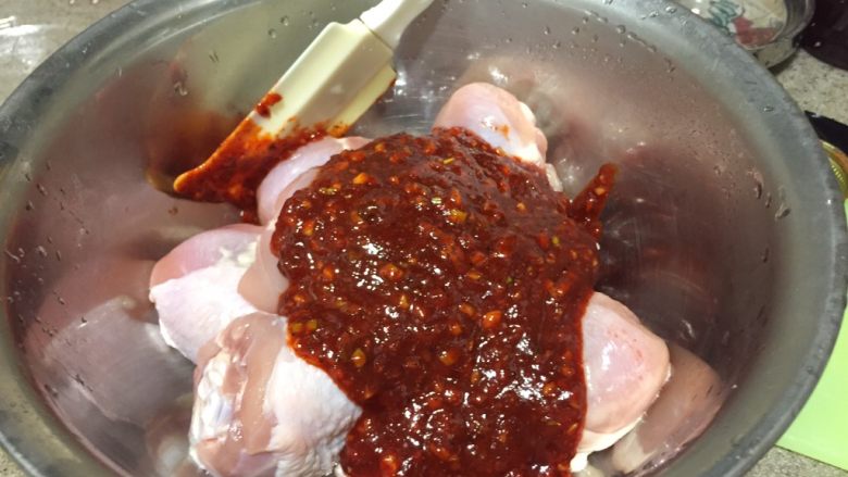 韩式香蒜辣烤鸡,从冰箱取出腌好的鸡肉,倒出多余的酒。倒入拌好的酱汁。