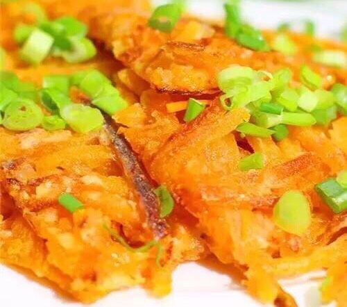 看图就想吃的香煎小葱南瓜饼,煎熟取出。用刀切开,装盘撒上葱花即可。
