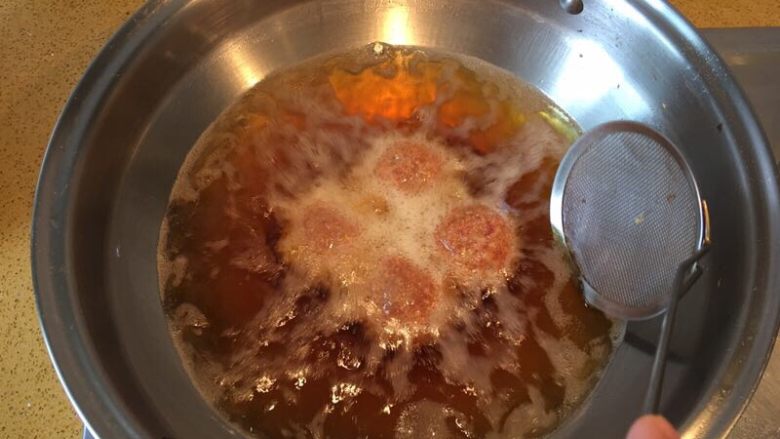 红烧狮子头,观察肉圆表面炸至金黄时即可捞出;