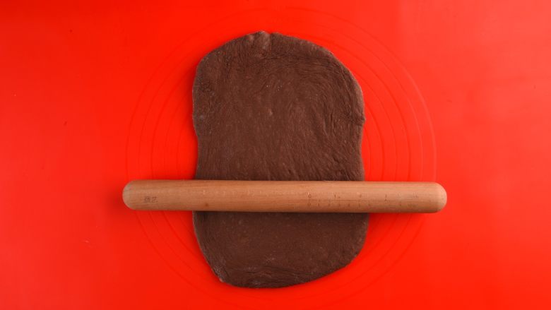 网红甜品丨麻薯夹心可可软欧,将其放在硅胶垫上用擀面杖擀开