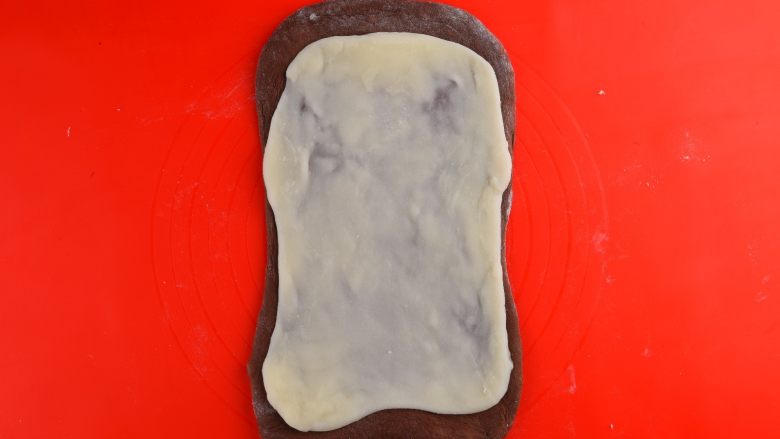 网红甜品丨麻薯夹心可可软欧,将麻薯团擀开后铺在面包面团上