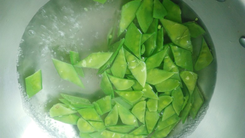 荷兰豆炒香肠,锅中烧水，水开，倒入荷兰豆，迅速淖水。