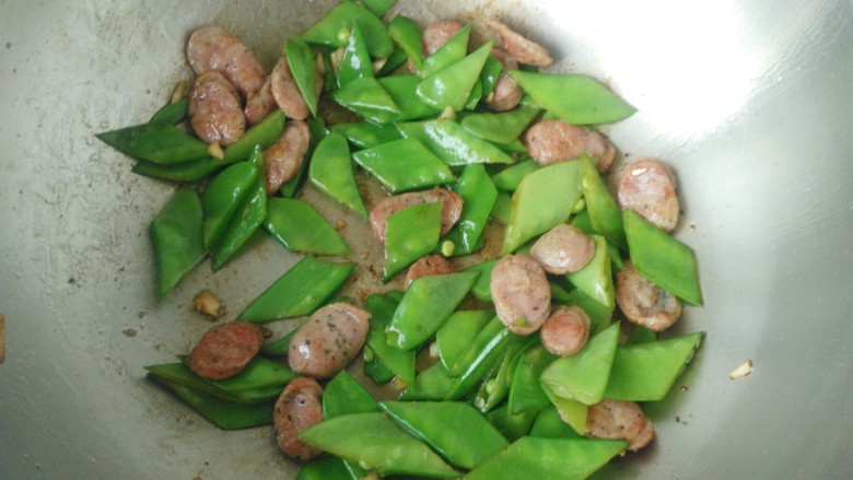 荷兰豆炒香肠,倒入沥干水的荷兰豆快速翻炒，入适量盐，几滴<a style='color:red;display:inline-block;' href='/shicai/ 788'>生抽</a>翻炒均匀出锅。