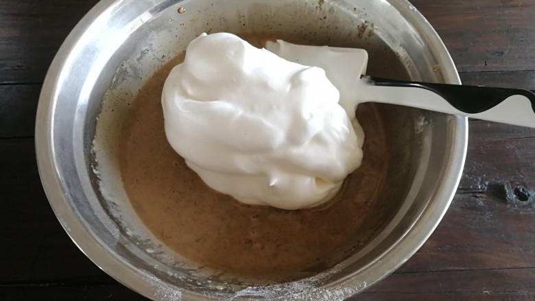 普洱茶牛奶戚风蛋糕,取1/3的蛋白到普洱茶蛋黄糊里面,采用切拌的方法进行操作。