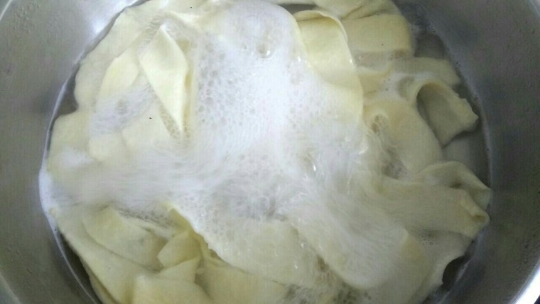 油泼面,锅里放水烧开,下入宽面片。下入面片时可以拉一下面片,使之更薄