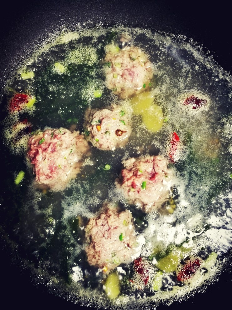 肉丸胡辣汤,海带丝煮五分钟,用手将准备好的牛肉捏成球形慢慢放进锅里