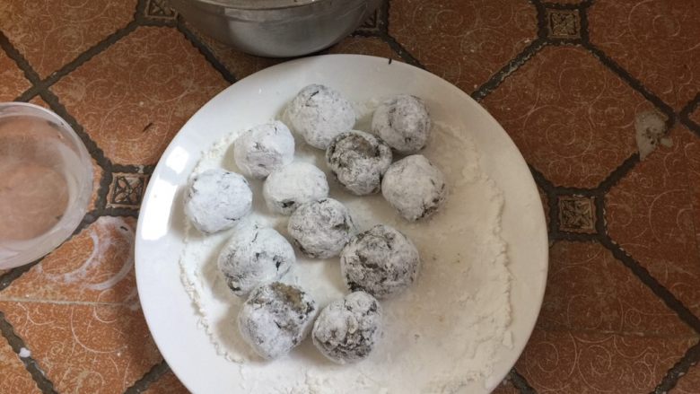 酥炸鱼球,然后放在生粉碟中轻轻滚动,使鱼丸表面裹上一层薄薄的生粉