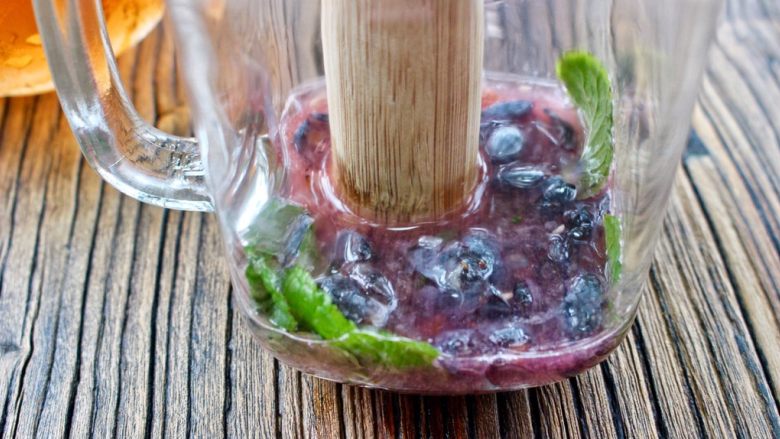 蓝莓Mojito鸡尾酒,用小棍压破蓝莓,挤压出水份