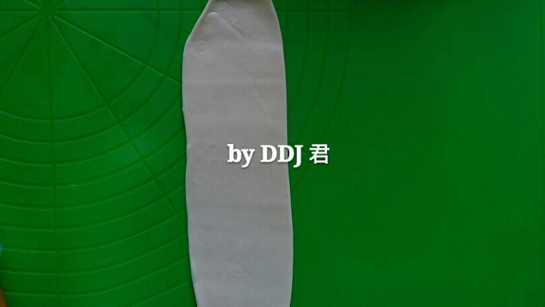 蛋黄酥,拿起一个包好的面团,收口朝下,用擀面杖擀成长舌状