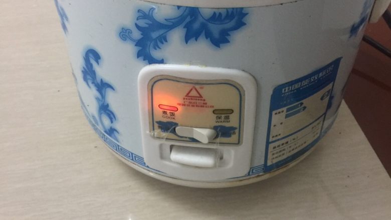 电饭锅煲仔饭,然后放电饭锅里,盖上盖子,打煮饭开关,煮到自然保温即可
