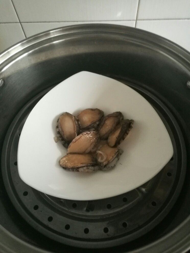 家常鲍鱼捞饭,蒸锅加水烧开后,放入鲍鱼,根据鲍鱼的大小蒸3-5分钟。蒸的时间不要过长,以防口感过老。