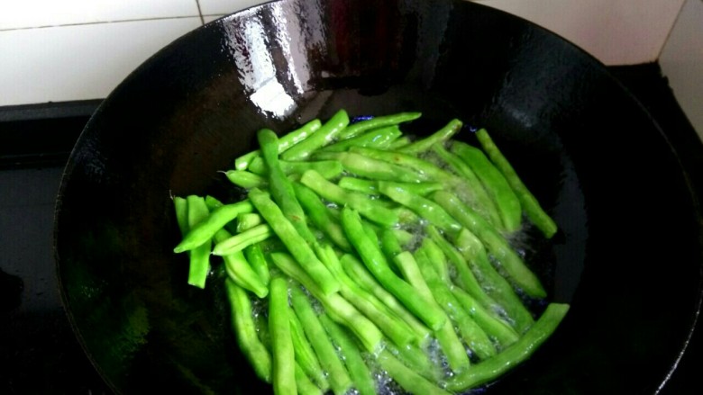 干煸豆角,油七分热,下入豆角煎炸