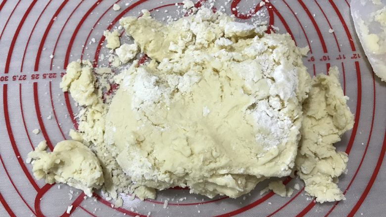 抹茶冰激凌夹心曲奇,在不粘硅胶垫上铺好剩余的70g低筋粉,将面团挖出来放在上面,戴上手套揉匀面团