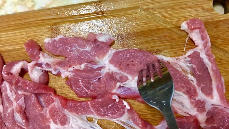 酥炸紅糟燒肉,用叉子在梅花豬肉上刺孔,這樣可以使肉吸收更多的醬汁