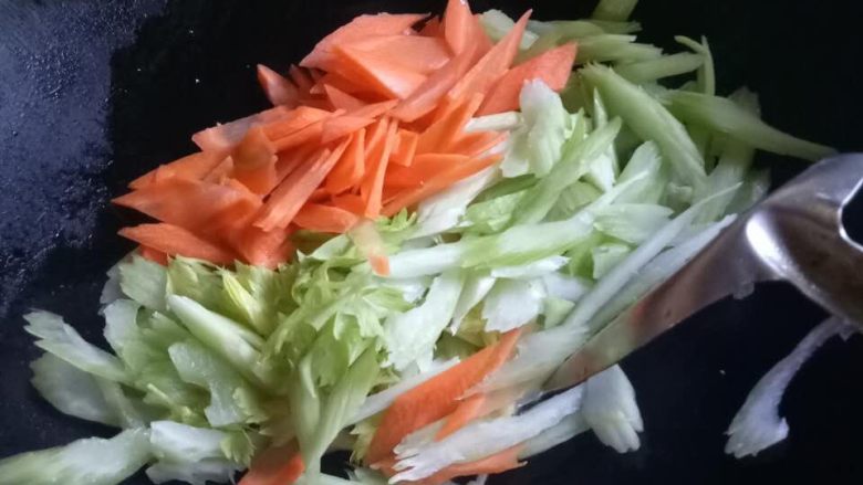 胡萝卜炒西芹,锅中倒入油下蒜末,炒香然后放胡萝卜西芹