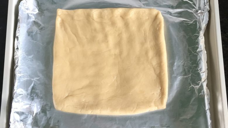 燕麦瓜子仁酥块,将面团放在铺了锡纸的烤盘里,借助刮板整型成一个方形,厚度1厘米左右;