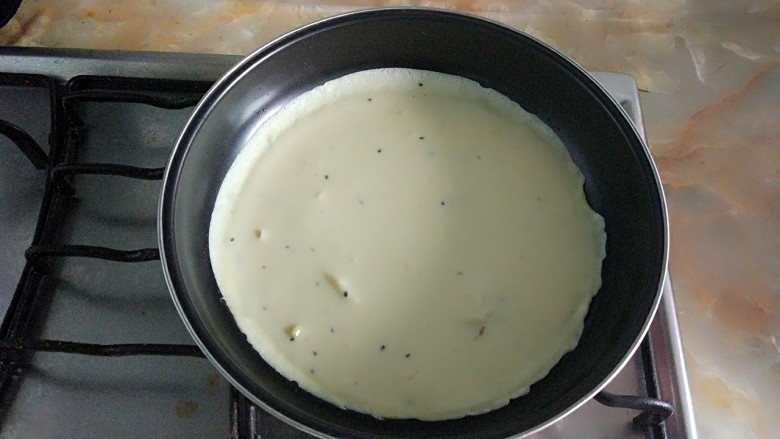 家庭版简易鸡蛋卷饼，双蛋青菜营养版,不需要再加油，倒入面糊，铺匀。