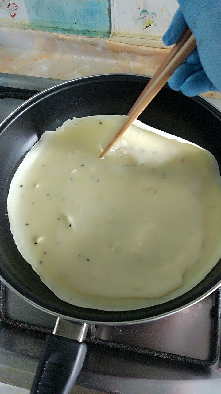 家庭版简易鸡蛋卷饼，双蛋青菜营养版,表面开始凝固，用筷子翻面。