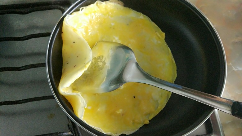 家庭版简易鸡蛋卷饼，双蛋青菜营养版,鸡蛋表面开始凝固时翻面。
