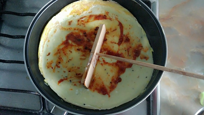 家庭版简易鸡蛋卷饼，双蛋青菜营养版,加入<a style='color:red;display:inline-block;' href='/shicai/ 5035'>辣酱</a>，铺匀，关火。