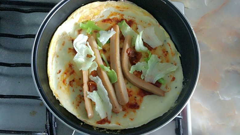 家庭版简易鸡蛋卷饼，双蛋青菜营养版,放入葱，香肠，生菜，用余热煎香。