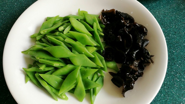 五花肉炒刀豆木耳,焯好水的刀豆切成菱形状,木耳切成小片。