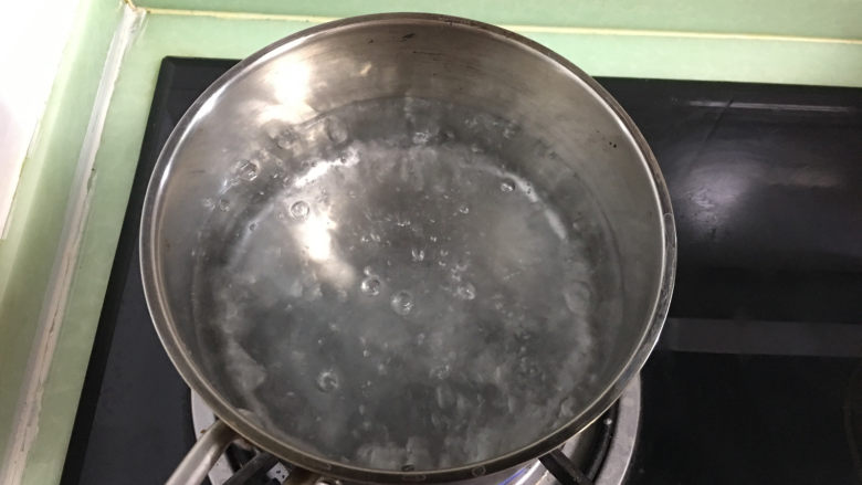 酸甜爽口的柠檬瓜条,取一个小锅,倒入水后煮沸。