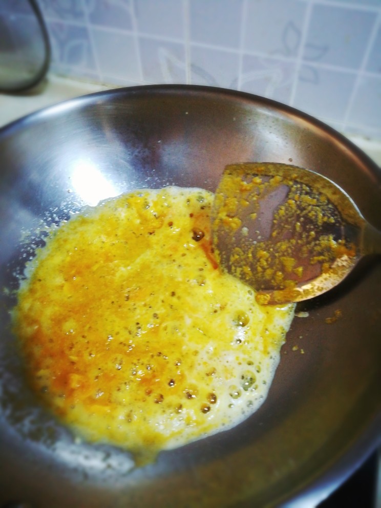 咸蛋黄炒土豆丝,起油锅，关小火，放入咸蛋黄碎炒散炒香，出现泡沫。
