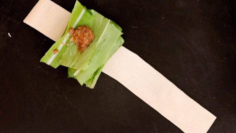 豆皮油麦菜卷,取一条豆皮,再取几段油麦菜放在豆皮上,在油麦菜上加入芝麻酱蘸料