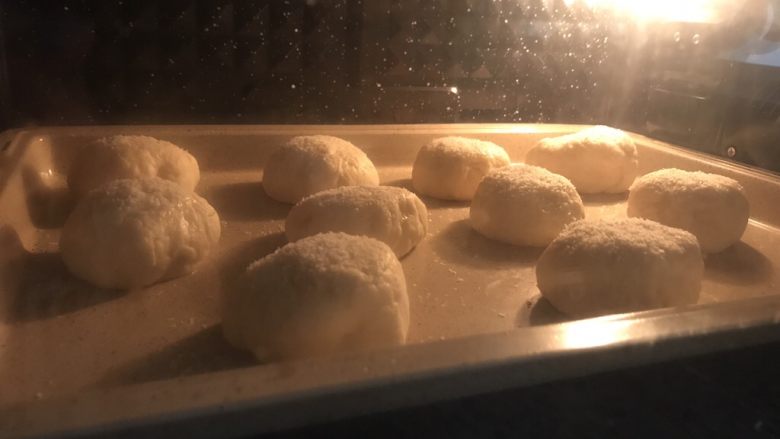 椰蓉奶酥夹心面包,包好馅的面团表面刷一层蛋液或者水,沾上椰蓉,放在烤盘上,最后发酵20分钟