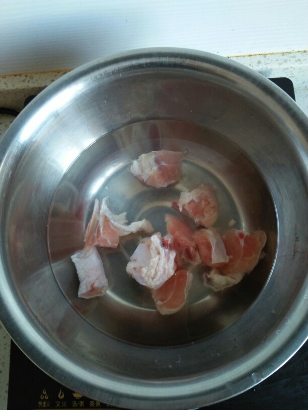 鸡腿炖土豆, 盆里放适量的水,把鸡腿放进去,把水烧开,焯一下鸡肉。