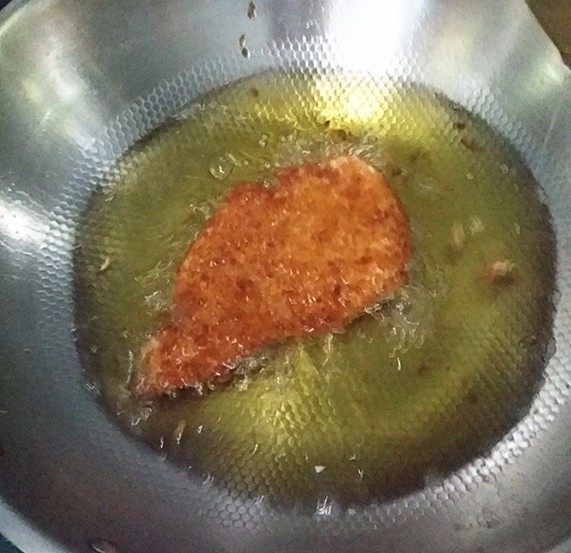 炸香酥鸡排,放入鸡排炸至两面金黄,捞出沥净多余油脂