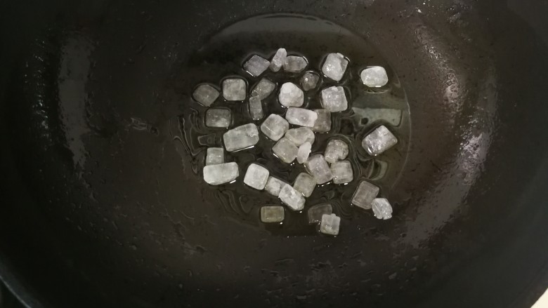卤猪蹄,锅加热后放入植物油 ,后放入冰糖,翻炒。