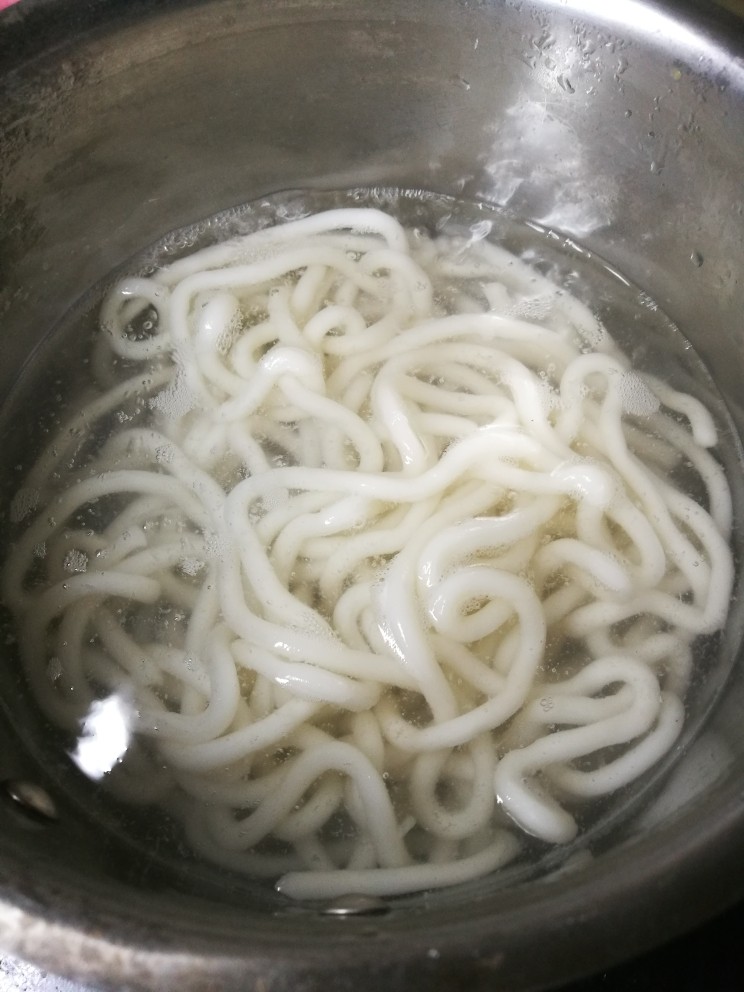 日式杂炒乌冬面,锅内水烧开后,将乌冬面汆开两分钟后捞出过凉。放一旁备用
