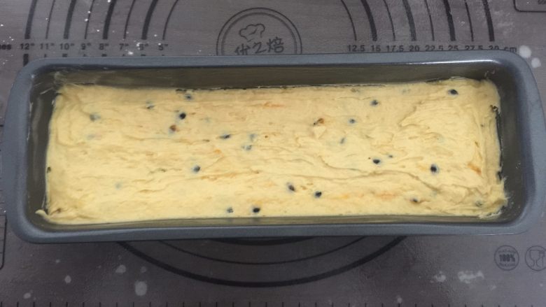 百香果磅蛋糕,倒入面糊,并用勺子将蛋糕糊抹成中间凹两边高