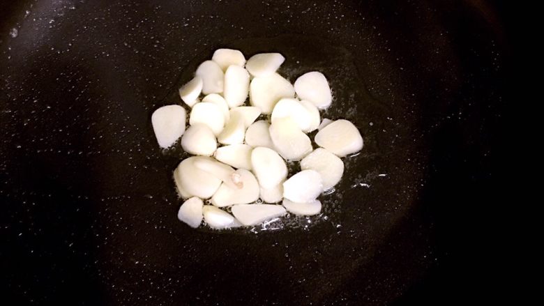 泡菜五花肉,倒入适量油,放入蒜,炒出香味。