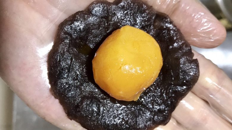 蛋黄酥,用豆沙把20个蛋黄包起来滚圆盖保鲜膜
