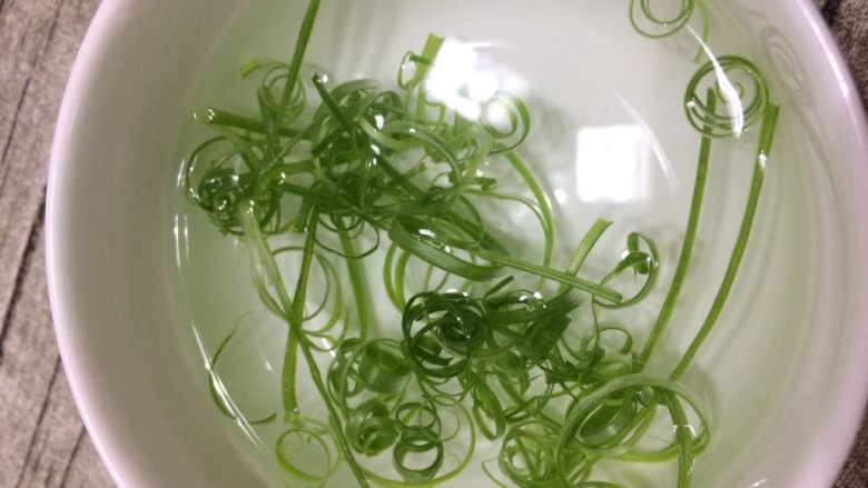 豆腐拌皮蛋,把葱绿泡在清水中,就会变卷。
