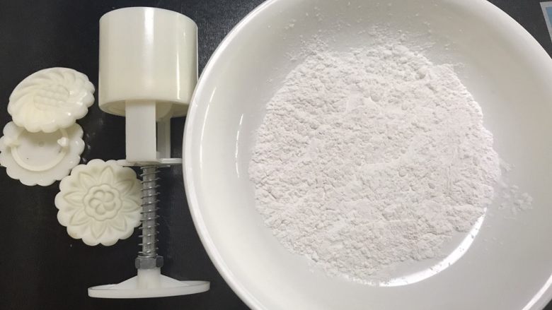 广式红豆沙月饼,准备好熟糯米粉跟月饼模具,熟糯米粉可以放容器里盖保鲜膜上锅大火蒸半个小时,也可以炒熟,