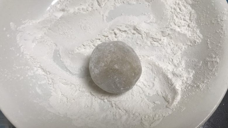 广式红豆沙月饼,包好的月饼胚放在糯米粉的盘子里滚一下,用手搓掉多余的粉