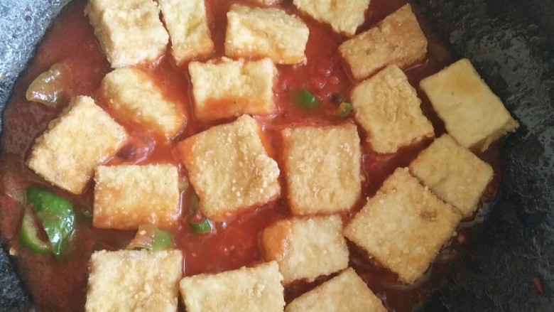 茄汁煎豆腐,把炸豆腐的油静置一会儿,用小勺舀一些上层清油备用,把锅洗干净,再把刚刚舀出来的油烧热,中火煸炒一下青椒让青椒的辣味出来,再把打好的西红柿汁倒进去,直到茄汁冒泡加入方才榨好的豆腐。让茄汁均匀裹在豆腐上,大火收汁。