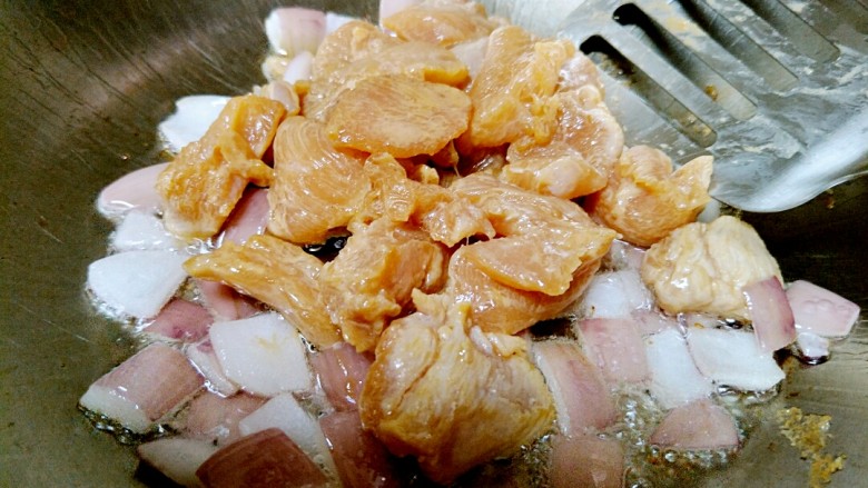 土豆炖鸡肉,放洋葱炒出香味,倒入腌好的鸡肉翻炒。可以先倒在洋葱上,以免粘锅。