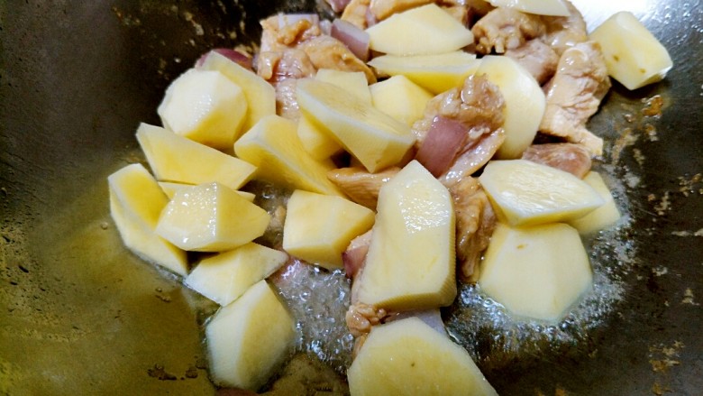 土豆炖鸡肉,放鸡肉翻炒至发白时,倒入切好的土豆块。(泡土豆的水不要倒)