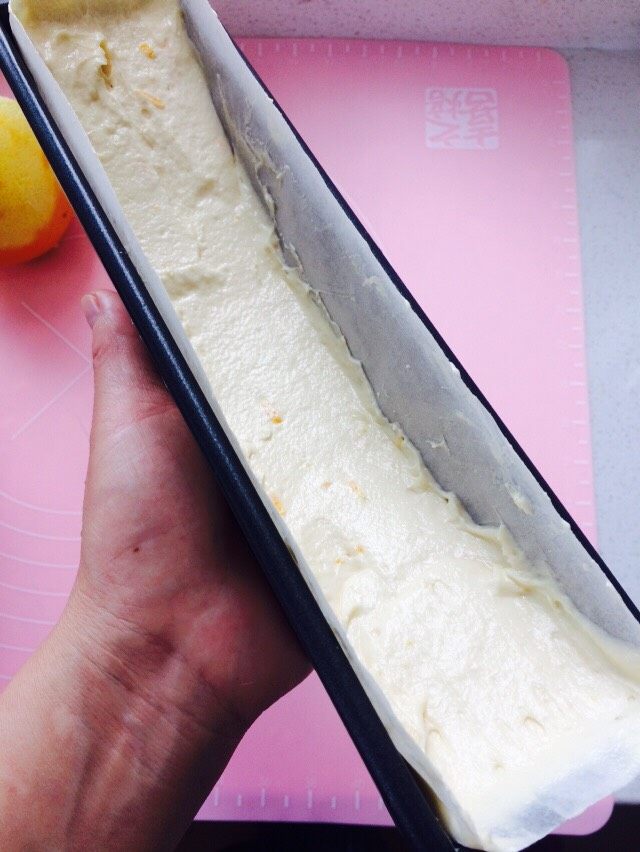 香橙磅蛋糕,面糊入模,中间低两端高,如图。放入先预热好的烤箱里。烤箱预热170度,烤制40一45分钟。