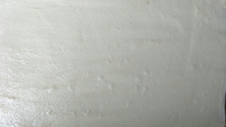 火腿香葱小花卷,往擀开的面皮上,撒一些面粉,倒上少许食用油,用刷子刷开。