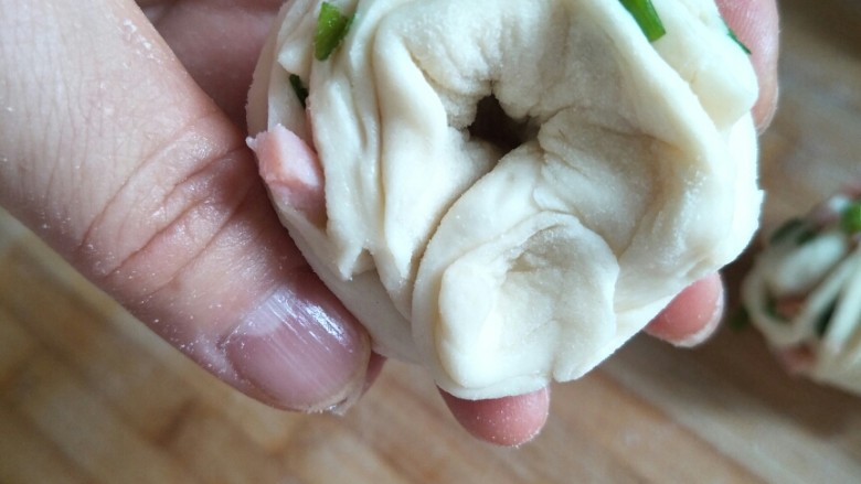 火腿香葱小花卷,在左手食指下捏实两端,抽出食指。