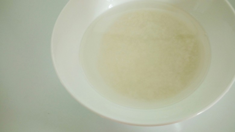 养生粥_,泡好的米倒掉水,米放入锅里煮。