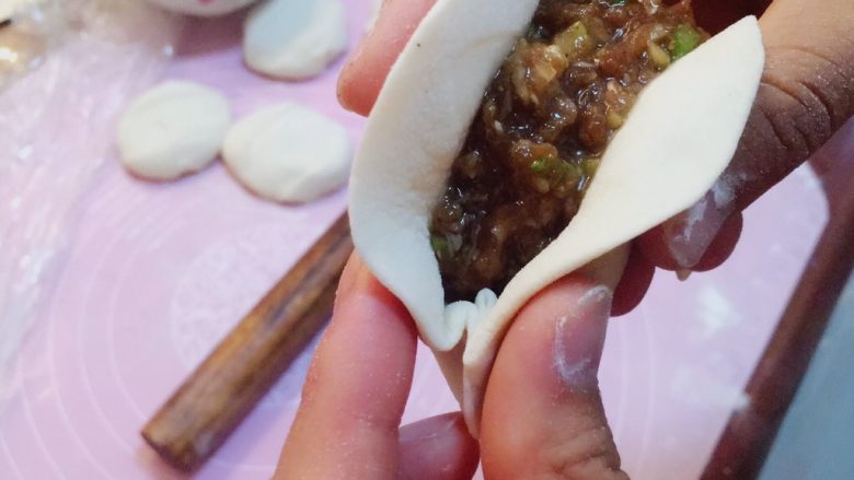 灌汤牛肉蒸饺,然后再用食指往前推动后面的面皮,再用另一只手捏紧,交替着这样捏,直到把整个饺子包完为止