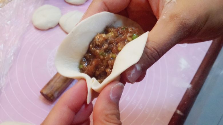 灌汤牛肉蒸饺,把皮对折,先在一端处捏一下,然后用右手的拇指往前推动面皮,另一只手的拇指捏紧(我习惯用左手来捏,大家可以根据自己的习惯调整方向)